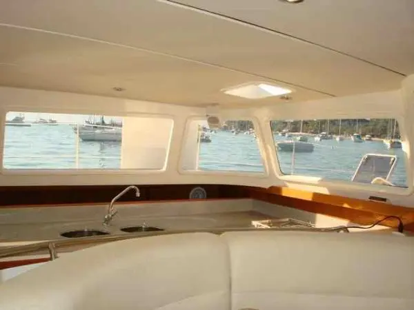 Área interna do Catamarã Dolphin 46 com cozinha e janelas panorâmicas oferecendo conforto e vistas incríveis