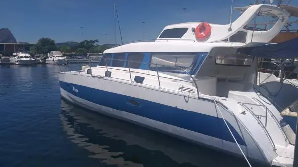 Catamarã Power Cat 40 ancorado em marina no Rio de Janeiro, destacando seu design moderno e ideal para aluguel de barco.