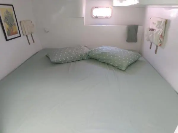 Quarto com decoração simples e cama de casal, ideal para aluguel com pernoite.