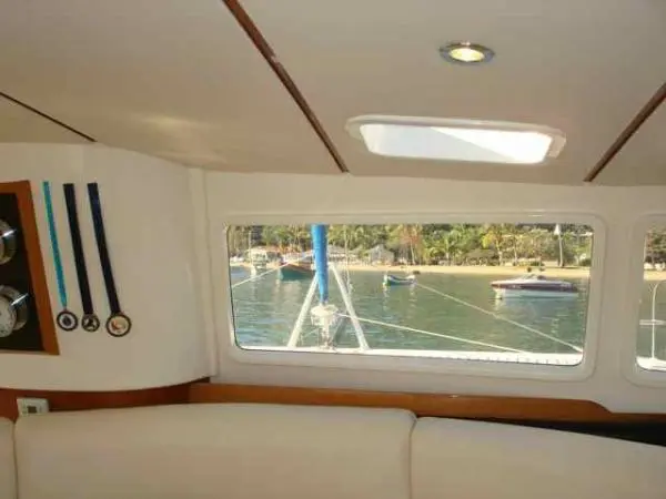 Vista para o exterior a partir do salão interno do Catamarã Dolphin 46, destacando a experiência única do aluguel