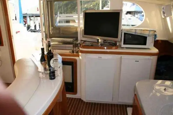 Cozinha equipada no Catamarã Dolphin 46, incluindo TV, micro-ondas e refrigeradores