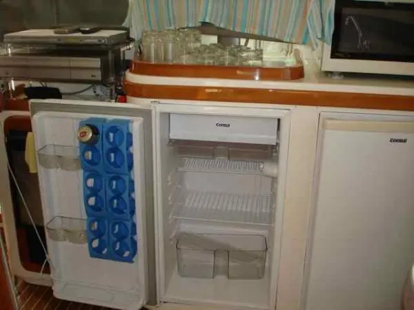 Refrigeradores abertos na cozinha do Catamarã Dolphin 46, mostrando amplo espaço para armazenamento