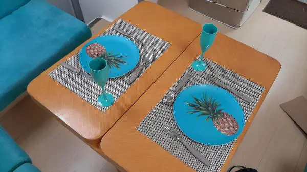 Mesa de jantar no interior do Catamarã Power Cat 40 com pratos temáticos, perfeita para eventos e passeios privativos.