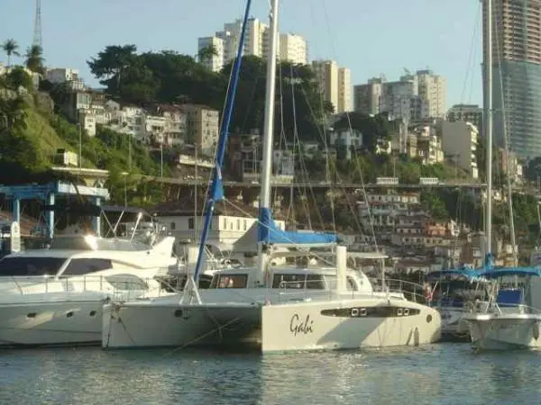 Catamarã Dolphin 46 ancorado próximo à costa com paisagem urbana ao fundo