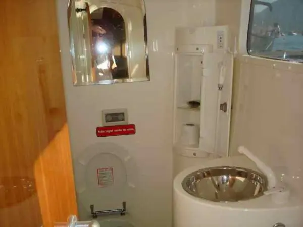 Banheiro do Catamarã Dolphin 46 com pia de inox e armários compactos