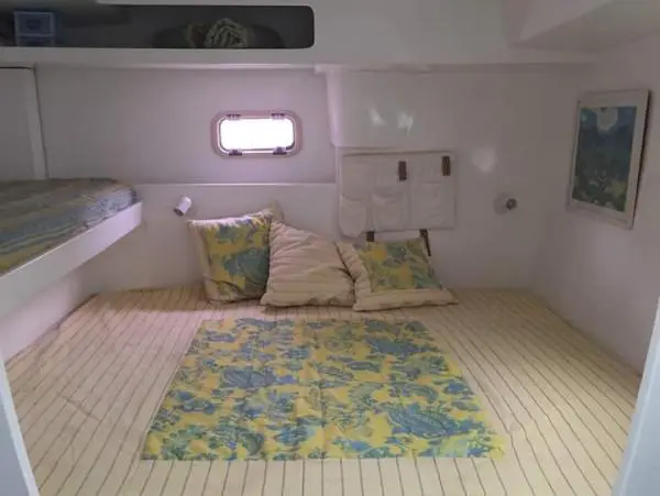 Suíte espaçosa no Catamarã Power Cat 40 com cama de casal e decoração confortável, ideal para noites a bordo.