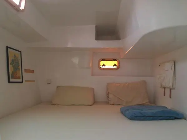 Quarto iluminado com cama de casal e decoração minimalista, perfeito para noites a bordo.