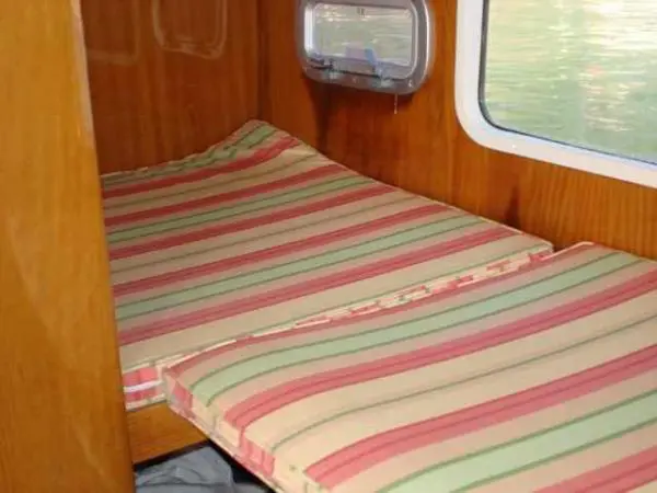 Cabine com camas de solteiro no Catamarã Dolphin 46, equipada com janela lateral