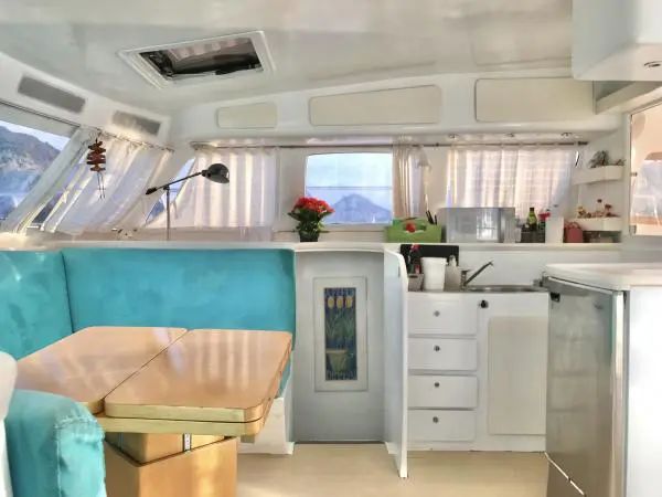 Interior moderno do Catamarã Power Cat 40 com cozinha equipada e área de jantar, ideal para aluguel de barco no Rio de Janeiro.