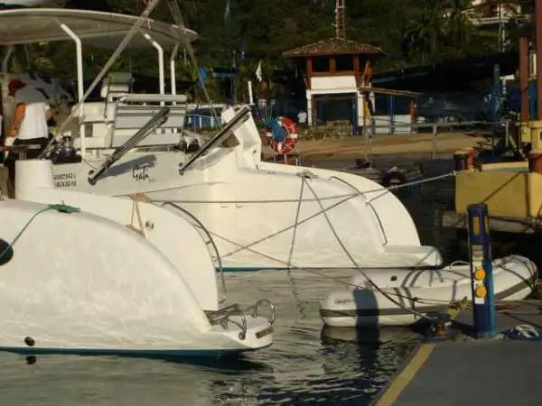 Popa do Catamarã Dolphin 46 com bote inflável atracado, em marina organizada