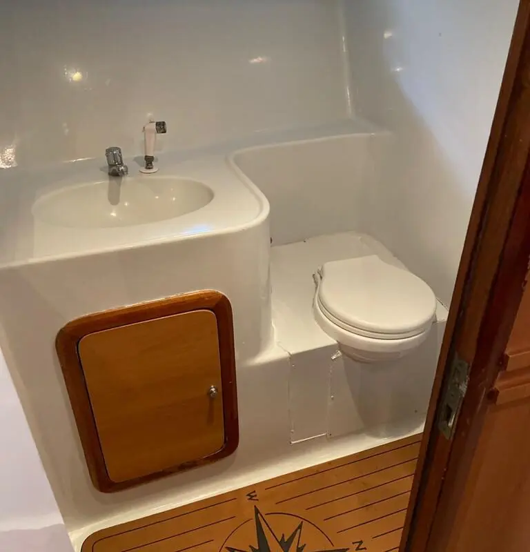 Banheiro da Lancha Rio Star 50 com pia, vaso sanitário e acabamento moderno.