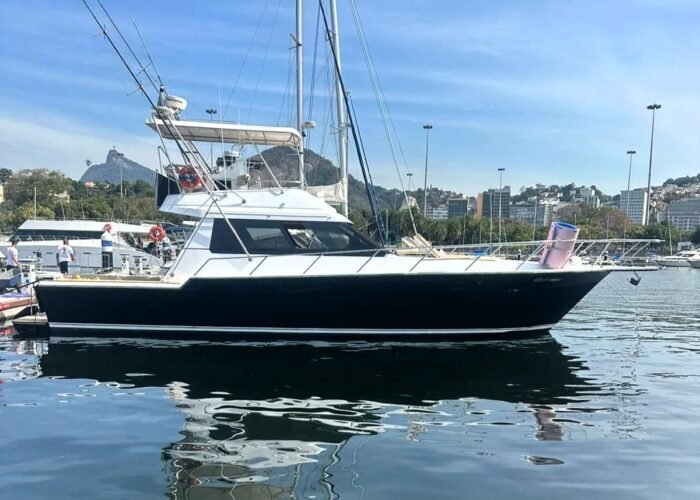 Lancha Rio Star 50 de casco preto atracada em marina no Rio de Janeiro, com o Corcovado ao fundo