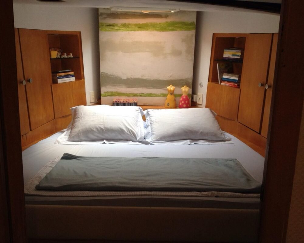 Quarto aconchegante com cama de casal no Trawler 50 pés, perfeito para descanso durante longos passeios.