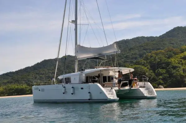 Catamarã Lagoon 450 ancorado em enseada de Angra dos Reis com mar verde e mata atlântica ao fundo