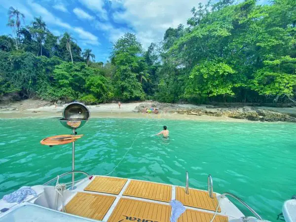 Passeio de lancha Coral 30 ancorada em praia de Angra dos Reis com churrasqueira a bordo