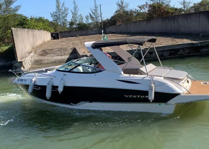 Lancha Ventura 265 com toldo bimini navegando em canal de águas calmas em Búzios