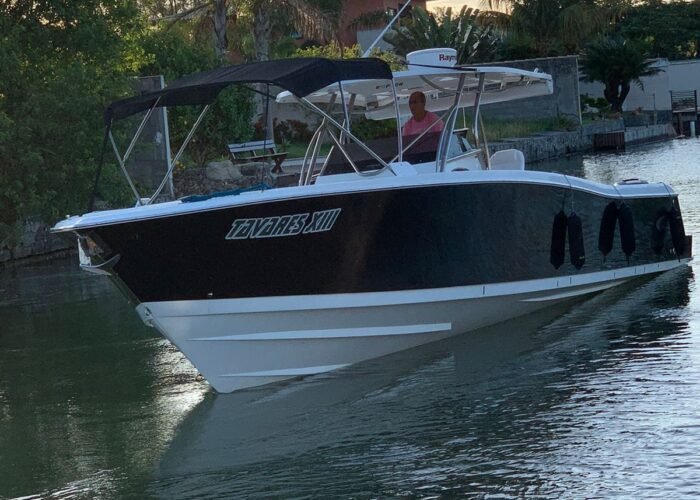 Lancha Raptor 375 vista de frente em água calma com toldo bimini aberto