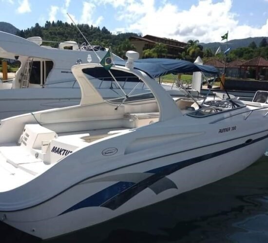 Lancha Runner 380 ancorada em um píer em Angra dos Reis, com design elegante e toldo azul.