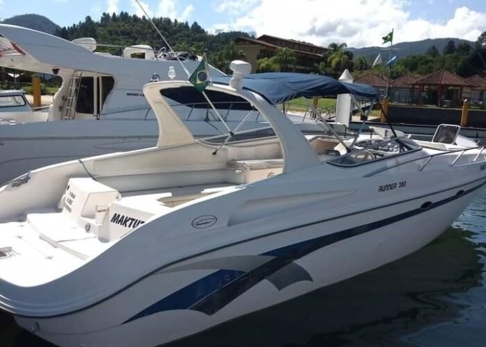 Lancha Runner 380 ancorada em um píer em Angra dos Reis, com design elegante e toldo azul.