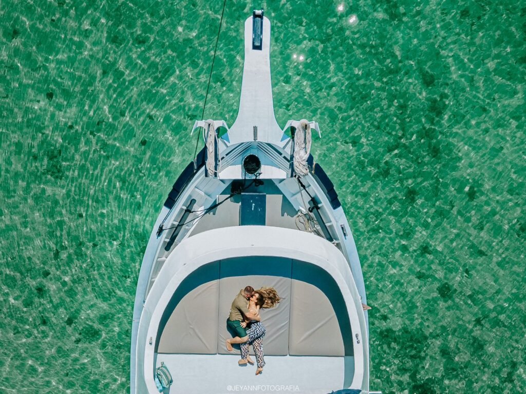 Casal relaxando na proa da Traineira 50 em águas claras de Angra dos Reis.
