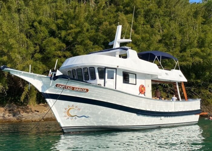Traineira 50 Capitão Garcia ancorada em Angra dos Reis, rodeada pela natureza.