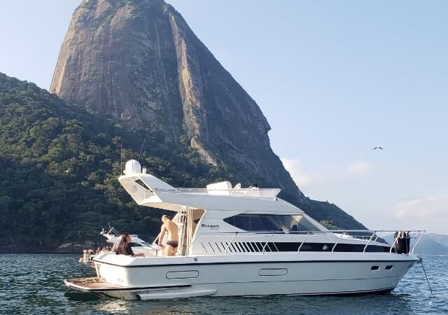 Lancha Oceanic 36 navegando próximo ao Pão de Açúcar, no Rio de Janeiro, durante passeio de barco exclusivo.