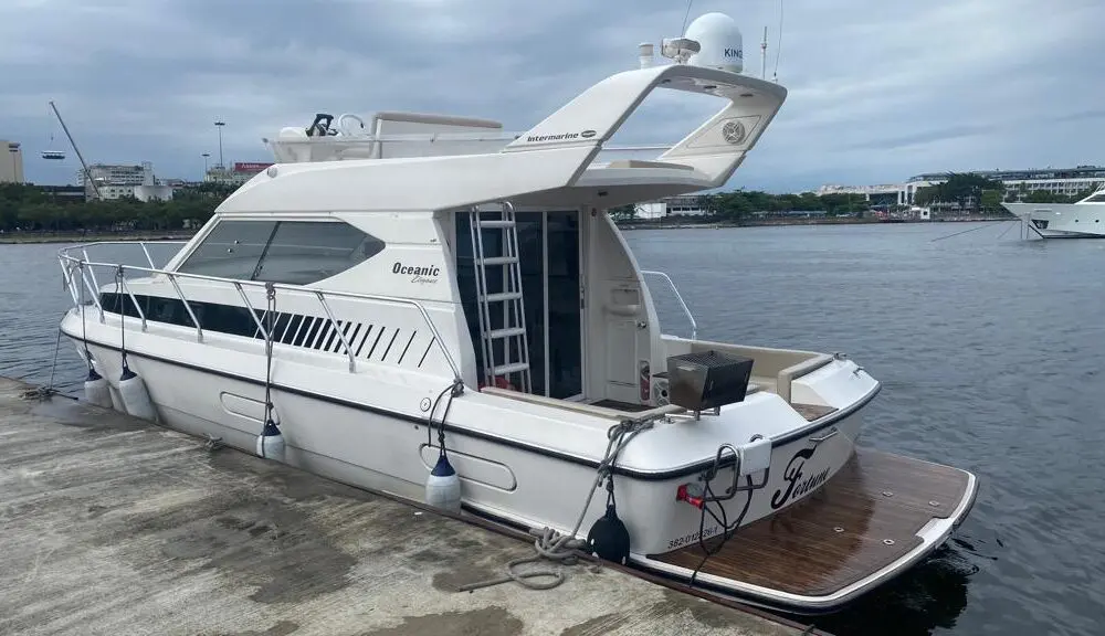 Vista lateral da lancha Oceanic 36 atracada no Rio de Janeiro, disponível para aluguel de lancha privativa.