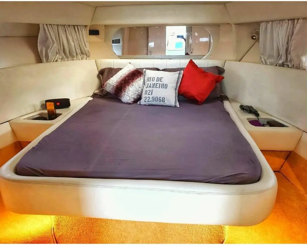Quarto da lancha Oceanic 36 com cama confortável, disponível para passeios de barco no Rio de Janeiro.