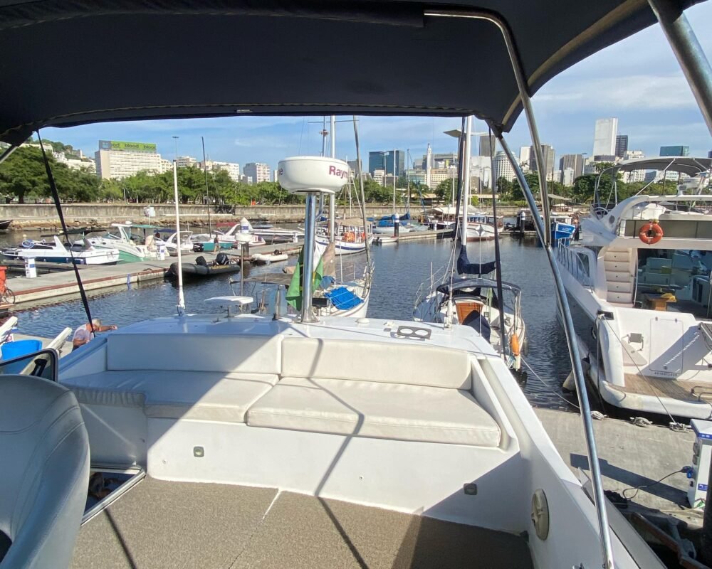 Flybridge com assentos acolchoados e cobertura para sombra, oferecendo uma vista panorâmica incrível. Ótima opção para quem busca aluguel de lancha para lazer.