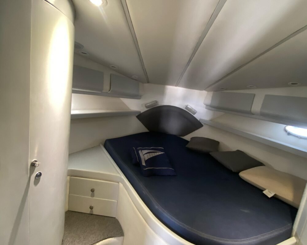 Suíte da lancha, com cama de casal, armários e iluminação aconchegante. Ideal para passeios com pernoite ou viagens de múltiplos dias.