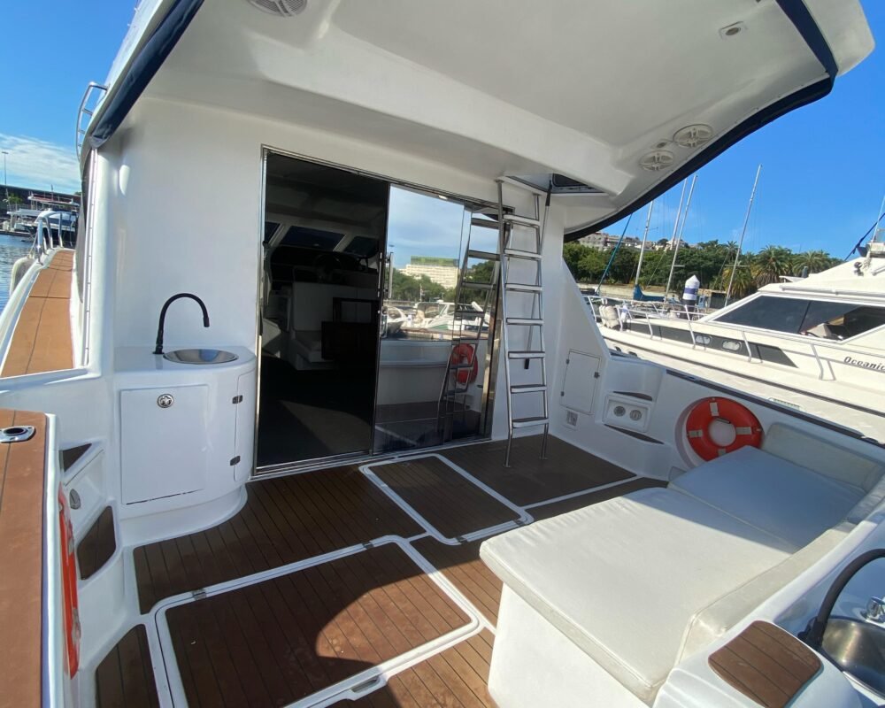Plataforma de popa da lancha Fast Senna 48, com área de convivência, assentos acolchoados e acesso ao flybridge. Ideal para passeios privativos no Rio de Janeiro.
