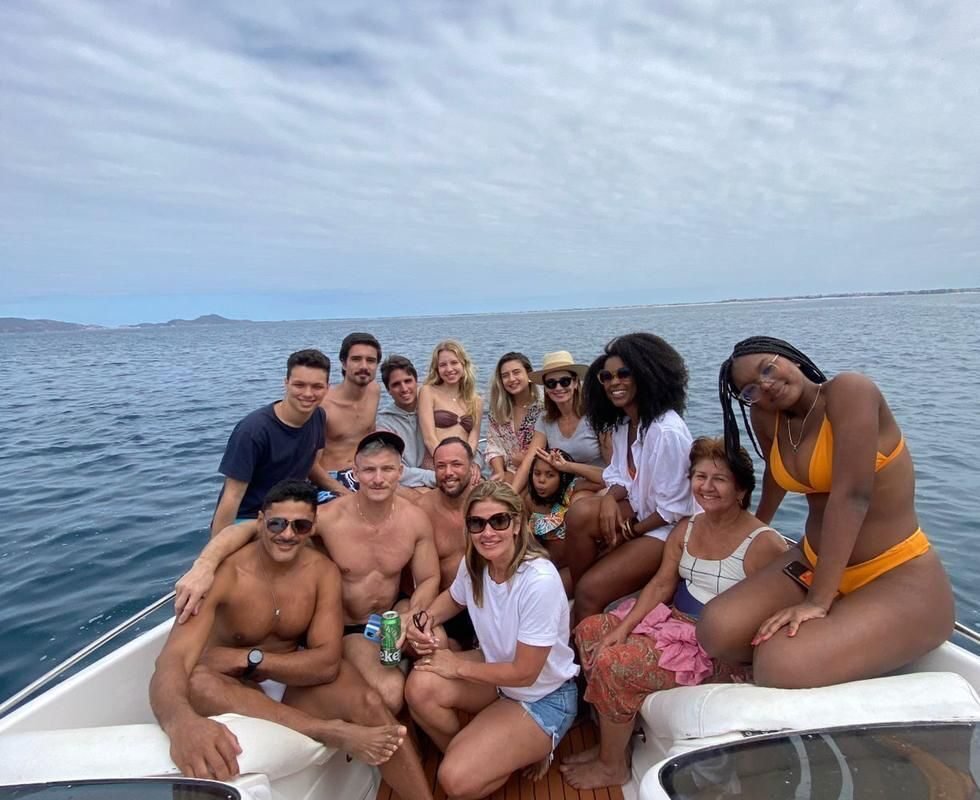 Grupo de pessoas posando para a foto em uma lancha.