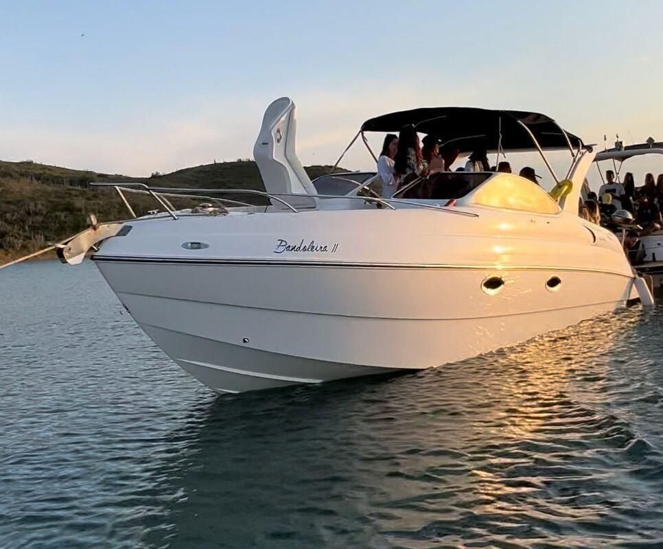 Lancha Coral 31 branca parada na água. Aluguel e passeio de Lancha Coral 31 pés em Cabo Frio branca parada no mar. Barco em Arraial do Cabo, Cabo Frio.
