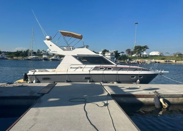 lancha Oceanic 36 Plus atracada em píer de marina, com flybridge coberto por toldo bege