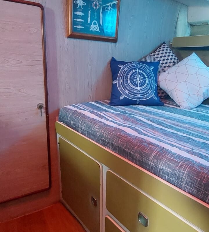 Interior da lancha Carbrasmar 39 com cama de casal e decoração náutica