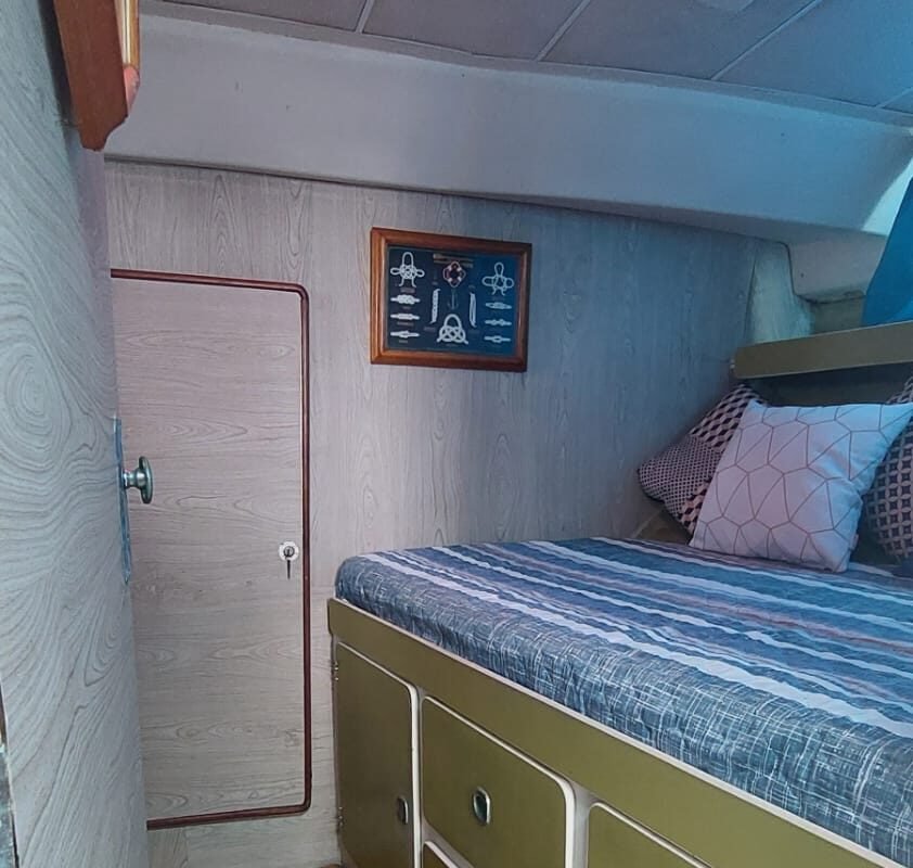 Cama de casal em cabine com escotilha iluminada