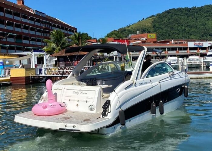 Lancha Cimitarra 34 na Marina Piratas, em Angra dos Reis, com boia de flamingo na popa e morro ao fundo