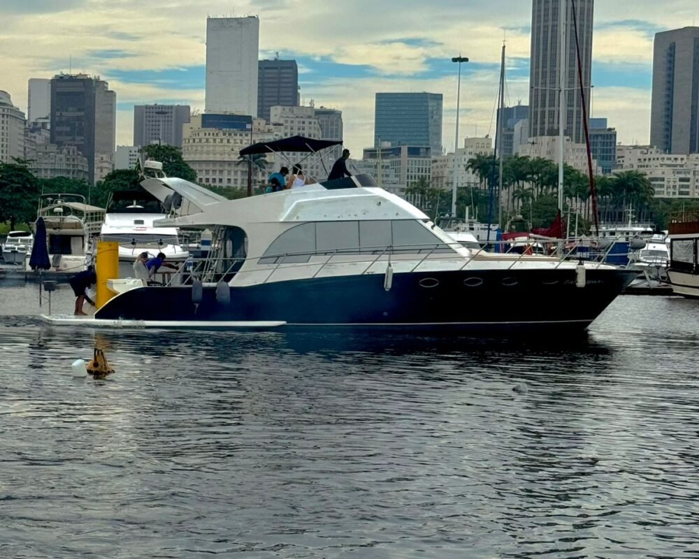 Lancha Tecnomarine 50 navegando tranquilamente na marina, com o skyline da cidade ao fundo.