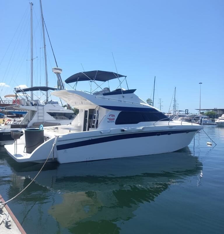 Vista lateral da Lancha Senna 42 atracada na marina, ideal para passeios de barco privativos no Rio de Janeiro.