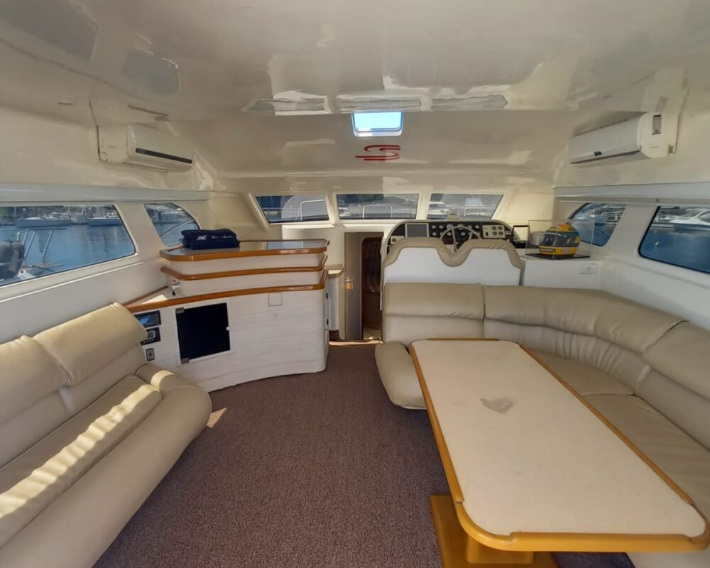 Sala de estar espaçosa e confortável na Lancha Senna 42, ideal para aluguel de barco no Rio de Janeiro.