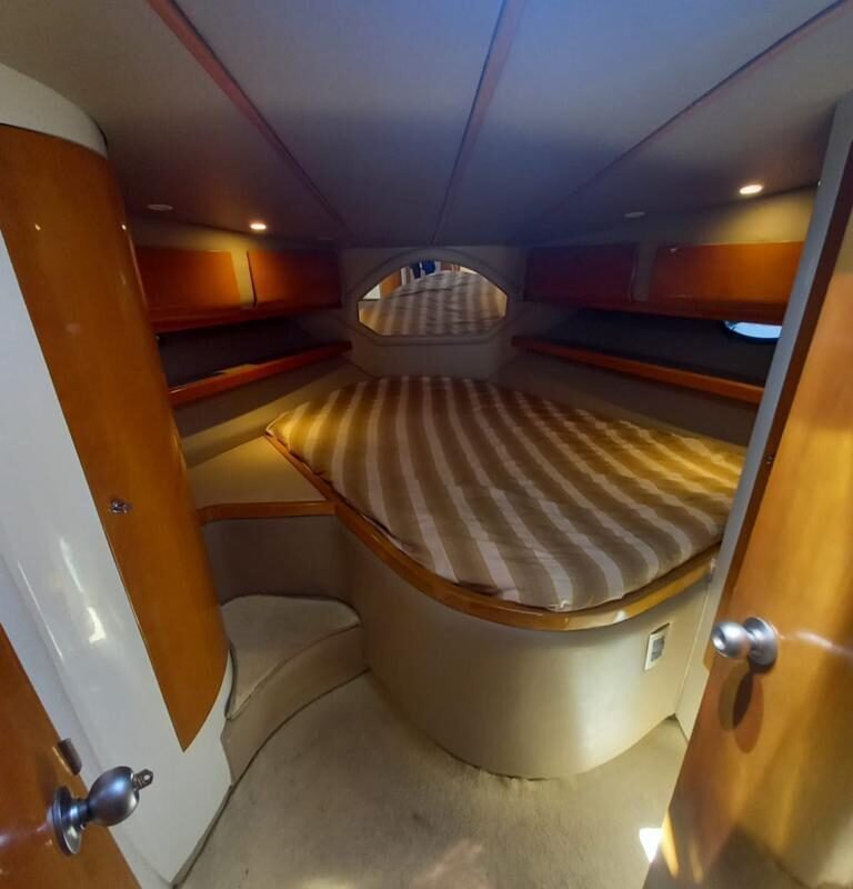 Cabine principal da Lancha Senna 42 com cama confortável, ideal para aluguel de barco no Rio de Janeiro.