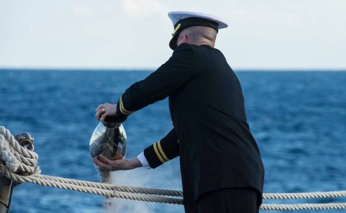 Oficial naval realiza cerimônia de dispersão de cinzas no mar.