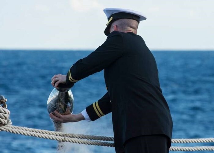 Oficial naval realiza cerimônia de dispersão de cinzas no mar.