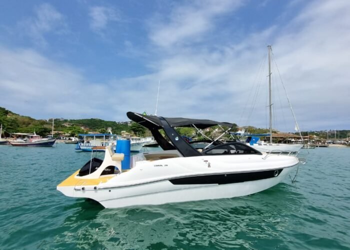 Lancha Coral 26 branca ancorada nas águas verdes da Marina de Búzios