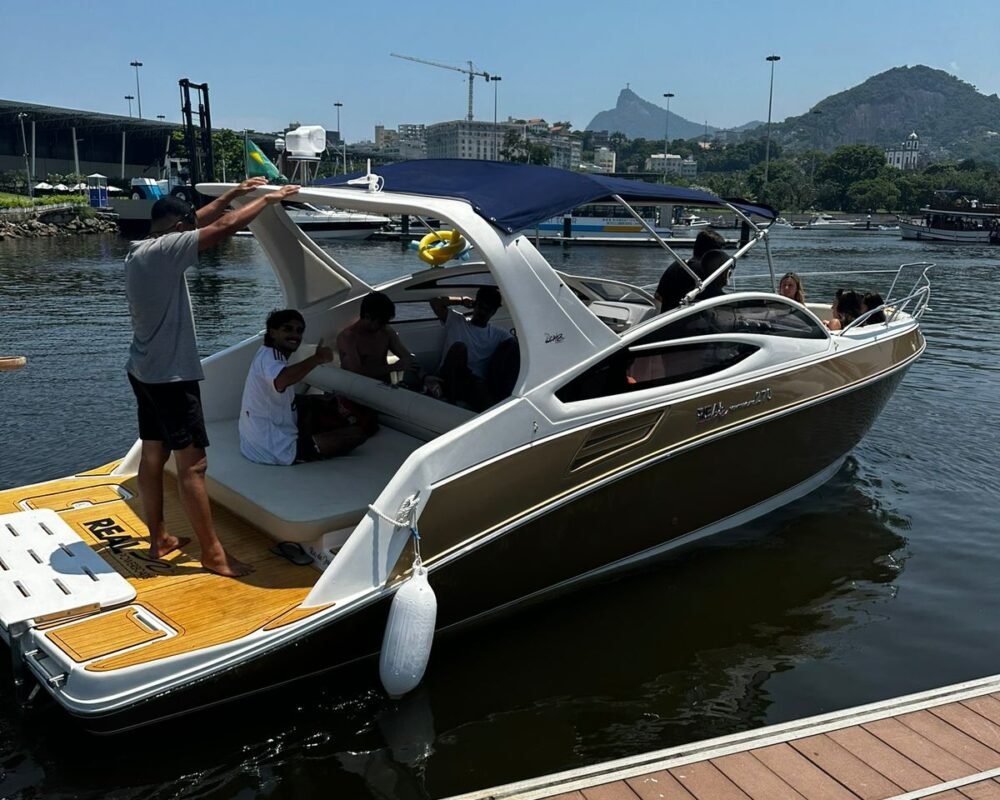 Lancha Real 270 atracada na Marina da Glória, com passageiros a bordo, pronta para um passeio pelo Rio de Janeiro.