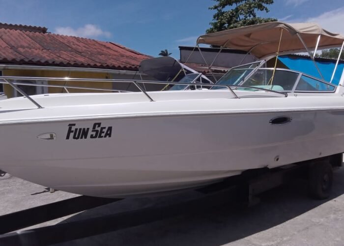 Lancha Tecnoboat 26 branca em pátio náutico, vista lateral com toldo bimini bege e para-brisas