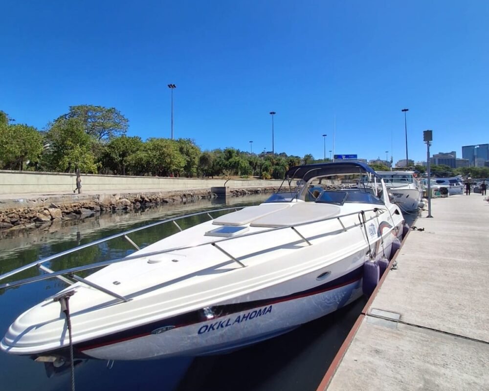 Lancha Runner 380 branca atracada no píer da marina, vista da proa, sob céu limpo