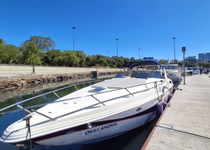 Lancha Runner 380 branca atracada no píer da marina, vista da proa, sob céu limpo