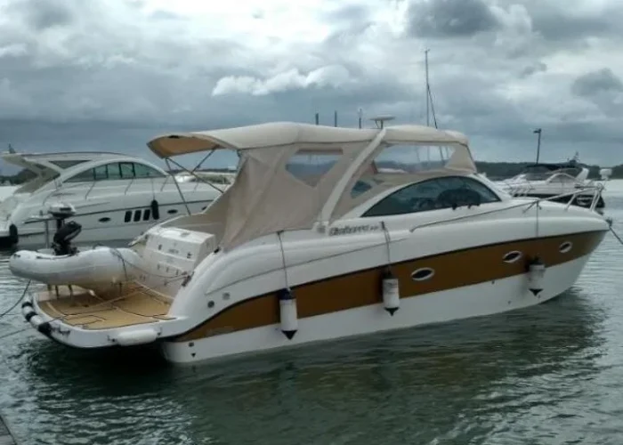 Lancha Cimitarra 34 Caribé atracada em marina, com capota e plataforma de popa