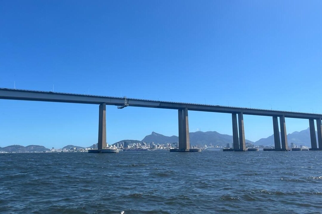 Vista da Ponte Rio-Niterói com o Pão de Açúcar ao fundo, capturada a partir de um passeio de barco pela Baía de Guanabara.